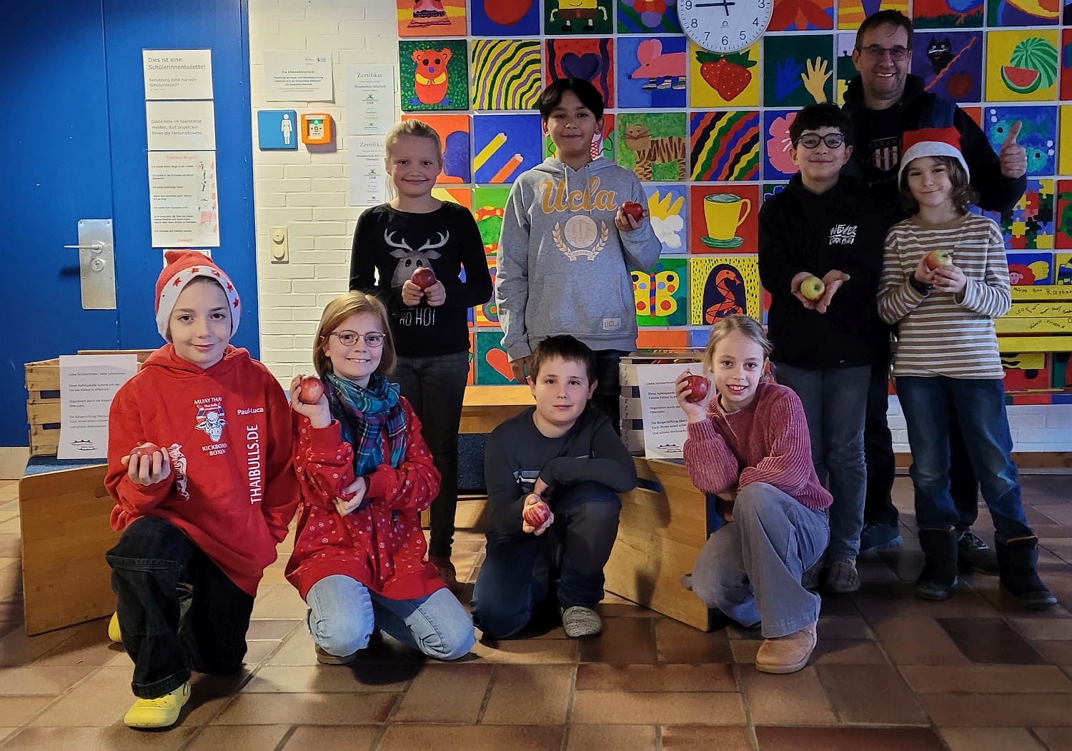 Rektor und Kinder der Schule mit einem Apfel in der Hand